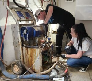 Two people repairing a machine